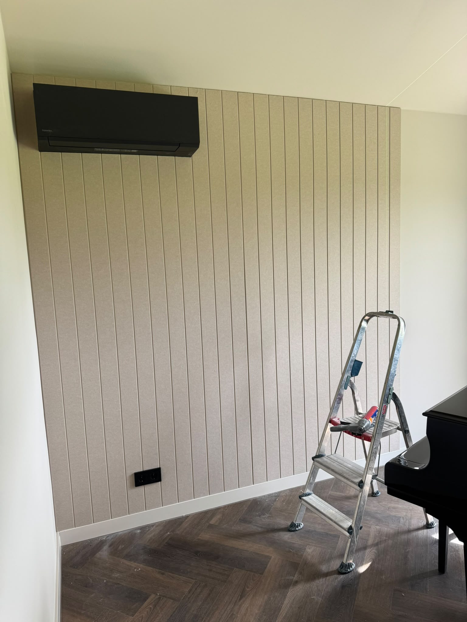 Binnenwand afgewerkt met verticale lamellenpanelen in warm beige