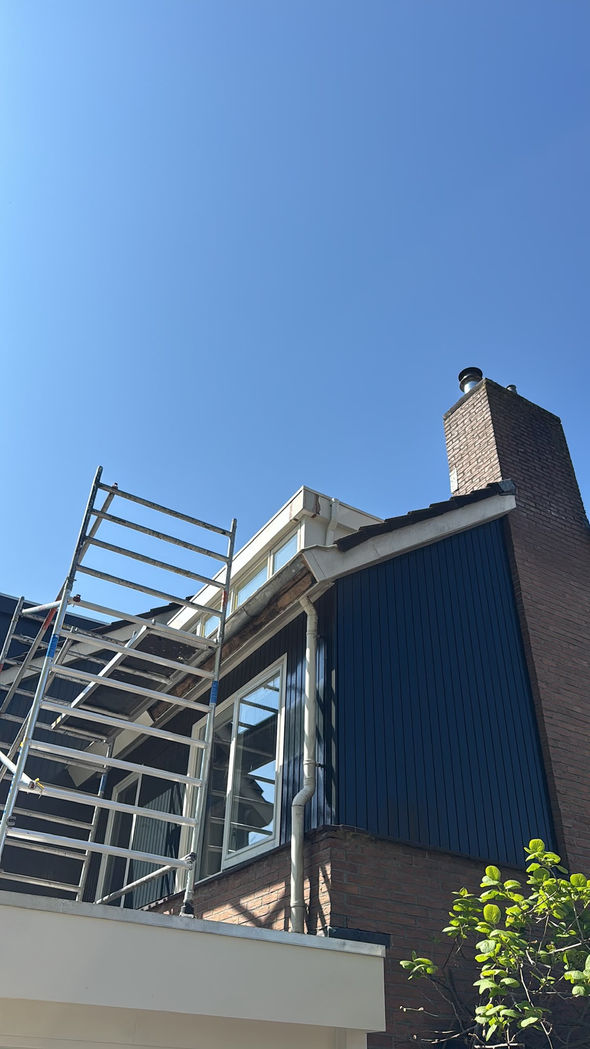 Dakkapel met nieuw donkerblauw beschot, tijdens werkzaamheden vanaf de steiger